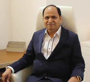 Smiling engineer in a yellow hard hat standing confidently at a construction site.