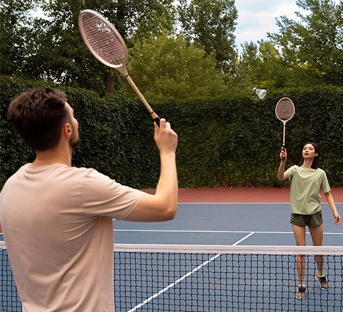 Happy woman holding a tennis racket on her shoulder after a game.