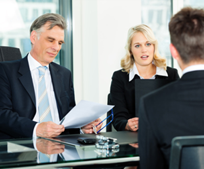 Professionals discussing property opportunities with an NRI investor during a formal meeting